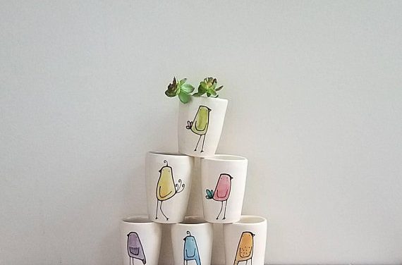 a small flock of rainbow colored bird vases