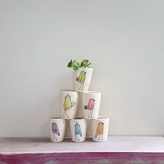 a small flock of rainbow colored bird vases